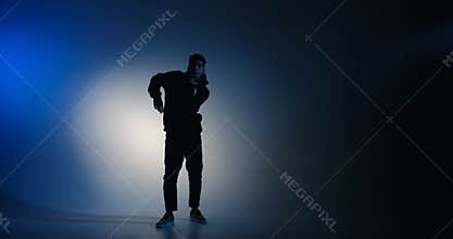 Young man break dancing in blue light