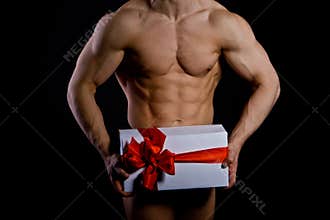 Handsome muscular young man holding a present
