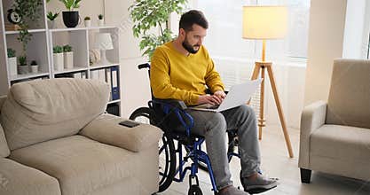 Disabled man with wife doing paperwork while working on laptop
