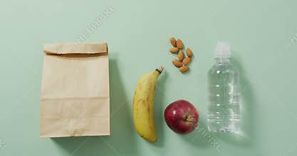 Animation of paper lunch bag an fruits on blue background