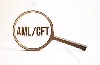 Magnifying glass with text aml cft on wooden table