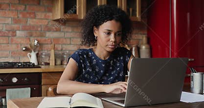 Black female student learn online using laptop write up information