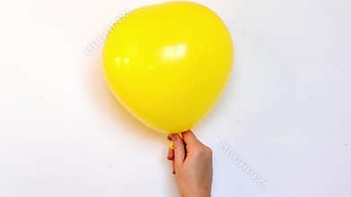 Yellow balloon in shape of heart inflating and deflating slowly video, symbol of love