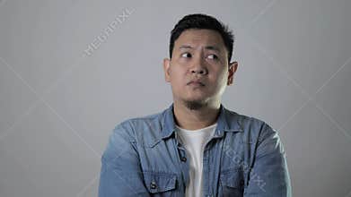 Asian man thinking something seriously, sad worried contemplation gesture