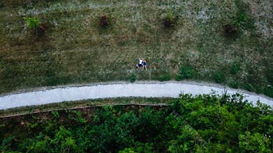 Young couple laying on the grass, drone photo, aerial perspective, bird`s eye view