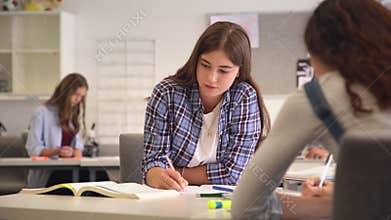 Smiling college girl studying in classroom