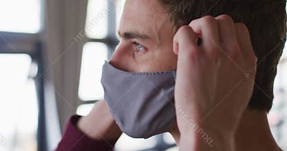 Caucasian man putting mask on