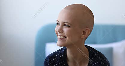 Dreamy millennial 20s bald headed girl feeling hopeful.