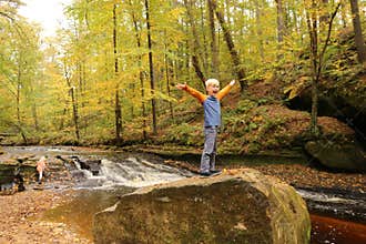 Happy Young Child Smiling with Excitement on Nature Hike near Ri