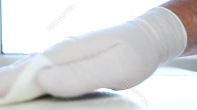 Close Up Man Hands with White Gloves Cleanse Furniture Surface Using Sprayed Cleaning Liquid