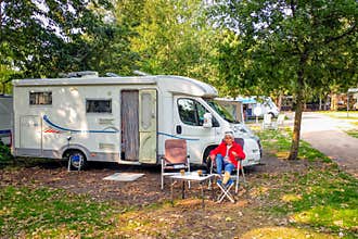 Enjoy a nice autumn sun next to the camper at a campsite.