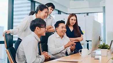 Millennial group of young businesspeople Asia businessman and businesswoman celebrate giving five after dealing feeling happy and