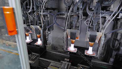 Car battery production line. Operation to establish contacts. Gas burners, melt the contacts into the housing.