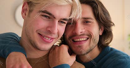 Loving gay couple embracing at home