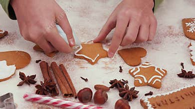 Child hands decorating a gingerbread christmas cookie