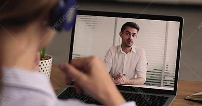Young woman in headphones holding job interview online.