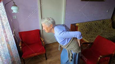 Elderly senior 75s woman with painful feelings in lumbar, massaging low back to reduce ache, suffer from backache