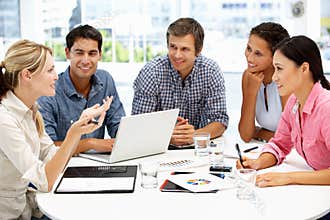 Mixed group around table in business meeting