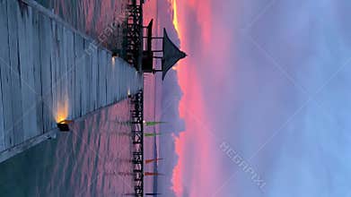 Pier Against Turquoise Sea In Kaimana Island At Sunset. Vertical Video Of Wooden Bungalow On Peaceful And Tranquil Pacific Lagoon