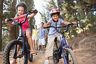 Family enjoying walk in the countryside with bikes