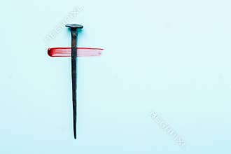 Christian cross made with rusty nails, drops of blood on blue background. Copy space. Good Friday, Easter day. Christian