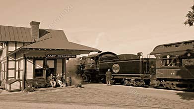 1950`s Black and White View of an Antique Steam Locomotive at a Train Station