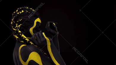 Face art. Dancing woman with black and yellow body paint. Young african girl with colorful bodypaint. An amazing afro