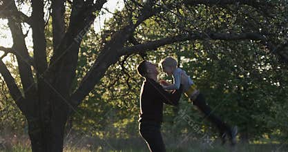 Boy jumping into fathers arms. Little son and father having fun in park, tossing up, throwing son in air.