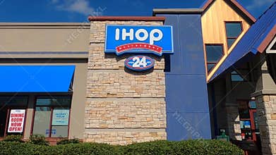 Pan of an IHOP restaurant building with window signs during the covid-19 pandemic