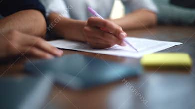 Close-up hands of unrecognizable business partners pointing with pens on paper documents while planning company goals