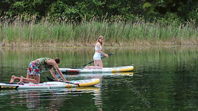 Man and woman sailing throw the river on the boards