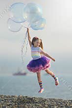 Rainbow dressed girl flying away on the bunch of soap bubbles