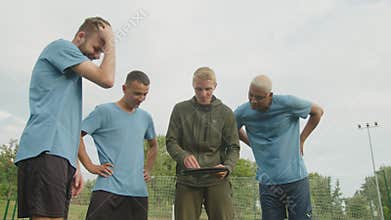 Soccer coach using tactic board, explaining scheme of game to players