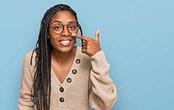 African american woman wearing casual clothes pointing with hand finger to face and nose, smiling cheerful