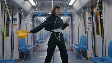 Lviv, Ukraine - March 21, 2021: Carefree woman in headphones dancing at empty subway