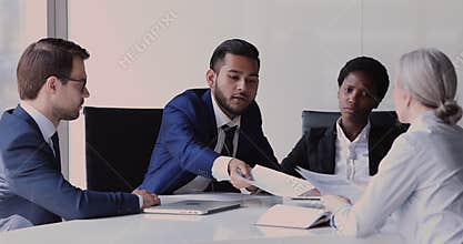 Group of diverse businesspeople reviewing project revenue during meeting