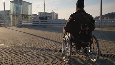 wheelchair-bound man in city, equipment and accessibility for disability people in modern town