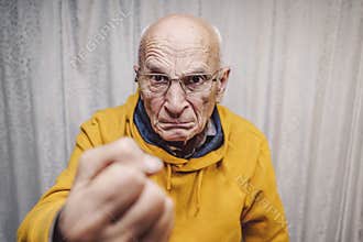 Portrait of angry caucasian man wearing eyeglasses and showing fist