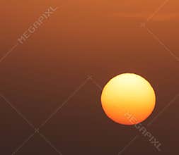 Glowing sun on dark orange sky