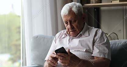 Smiling middle aged male pensioner pay online via mobile phone