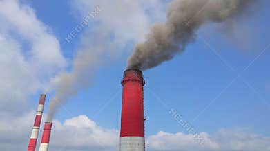 Aerial video. Slowmotion shot of a coal electric plant. Smoke coming out of three pipes of an old electric plant. Carbon