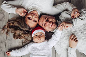Family portrait of baby in santa hat and his loving parents