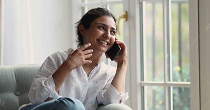 Beautiful Indian woman lead carefree conversation on smartphone
