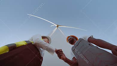Engineer and business woman wearing safety hats shake hands business deal, success work, teamwork, turbine wind clean