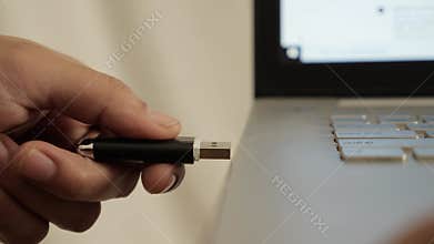 Person inserting plug in flashdisk into usb port in laptop personal computer, data transfer device concept
