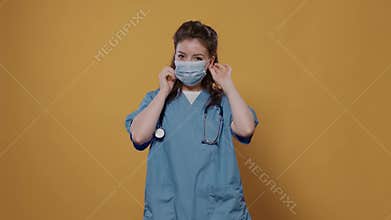 Woman doctor putting on surgical mask for protection against corona virus for covid pandemic awerness