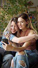 Two young lgbt ladies are talking news about their wedding to their relatives on the video call