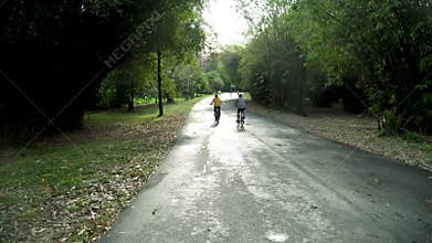 Asians ride healthy bicycles in the evening in the park. with sportswear, exercise with cycling for good health