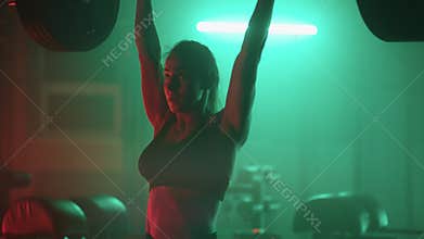 Slow motion: Athletic Beautiful Woman Does Overhead Deadlift with a Barbell in the Gym. Female Professional Bodybuilder