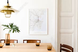 Stylish and eclectic dining room interior with mock up poster map, sharing table design chairs, gold pedant lamp and elegant sofa